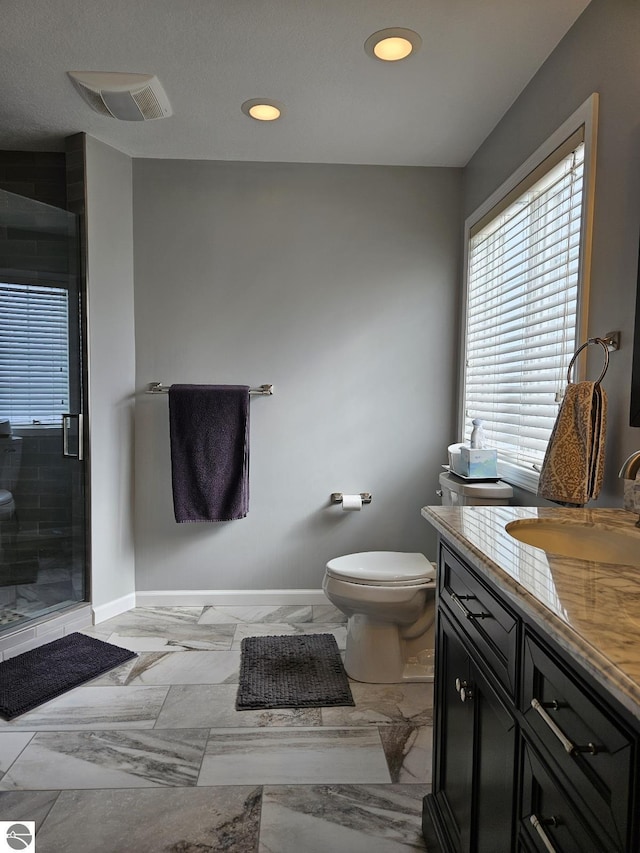 bathroom with a stall shower, baseboards, visible vents, toilet, and vanity