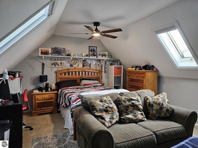 bedroom with lofted ceiling with skylight, carpet, and ceiling fan