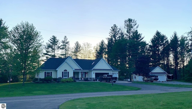 single story home featuring driveway, a front lawn, and an attached garage