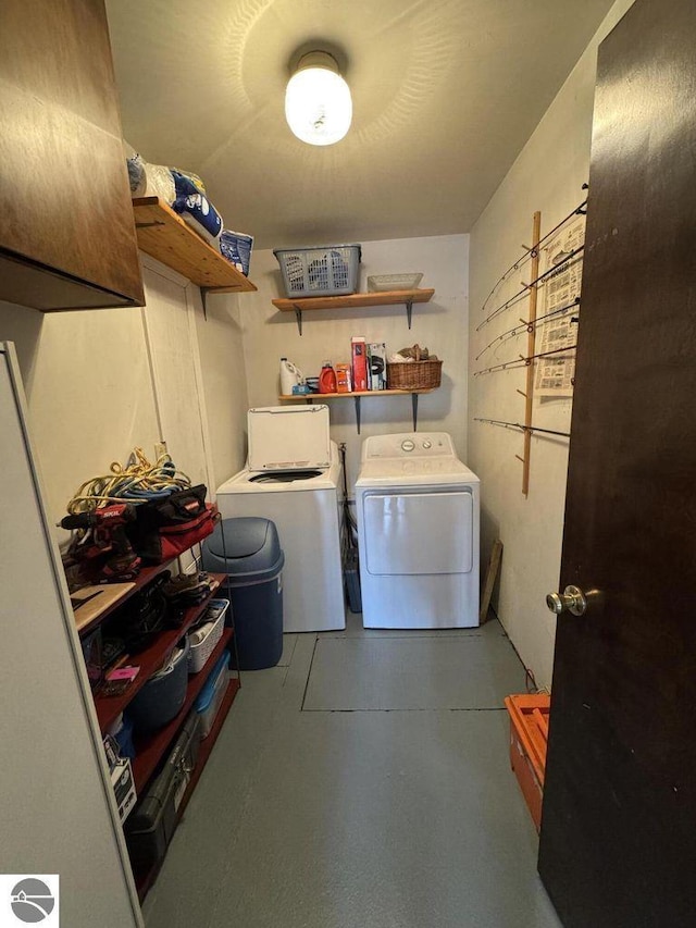 clothes washing area featuring cabinet space and washer and clothes dryer