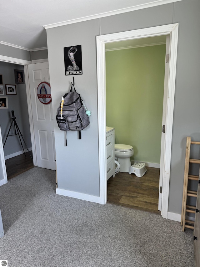 bathroom featuring ornamental molding, carpet flooring, baseboards, and toilet