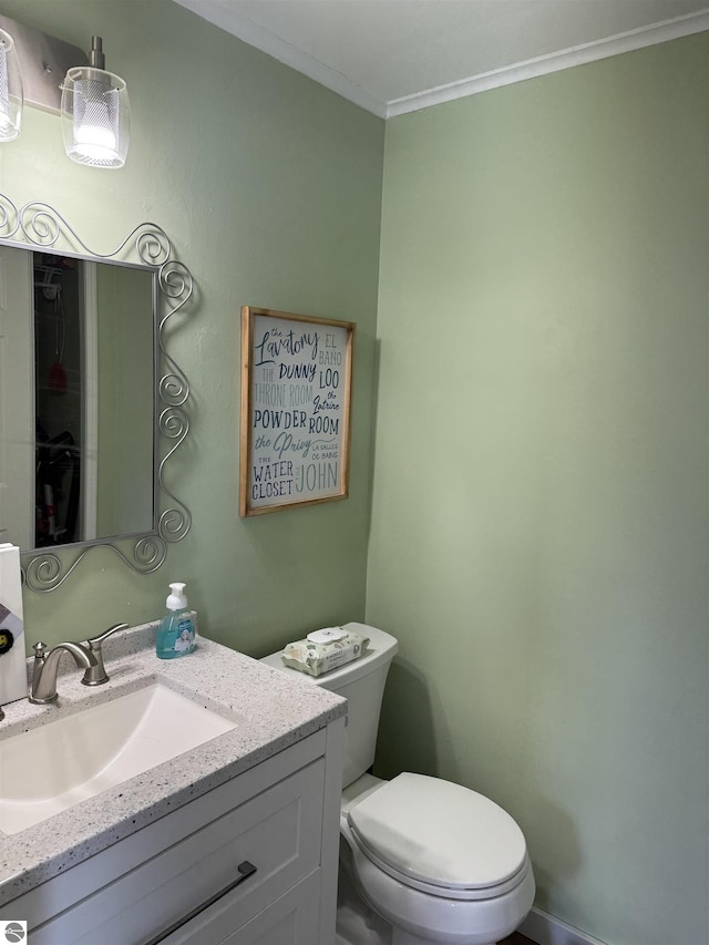 half bath with toilet, crown molding, and vanity