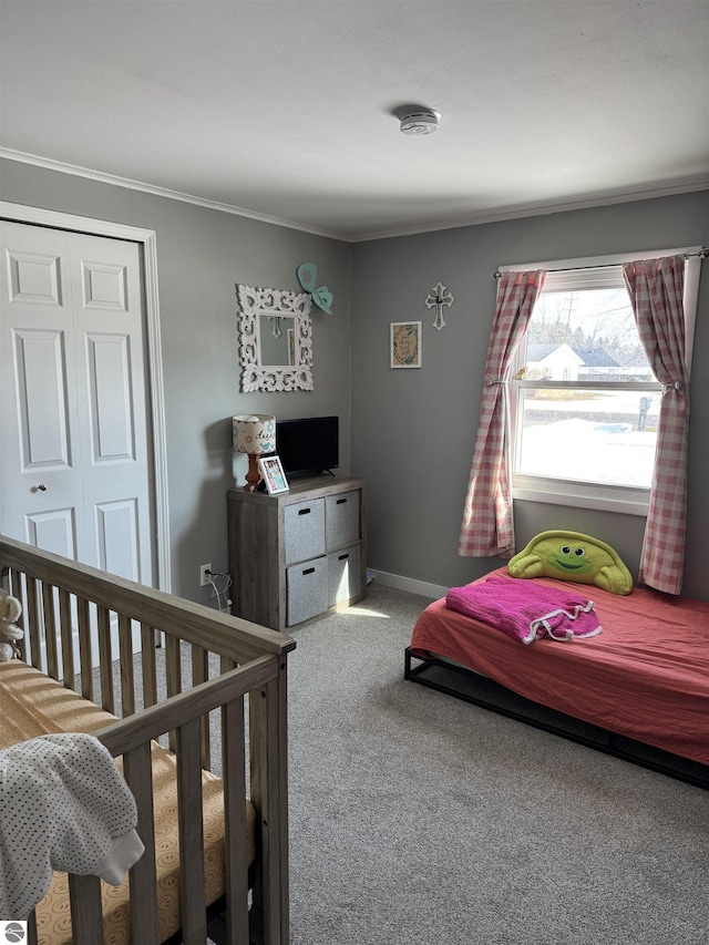 bedroom featuring crown molding, a closet, carpet, and baseboards