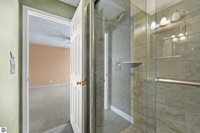 full bathroom featuring a shower stall and baseboards