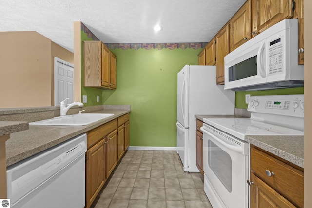 kitchen with white appliances, a sink, and brown cabinets