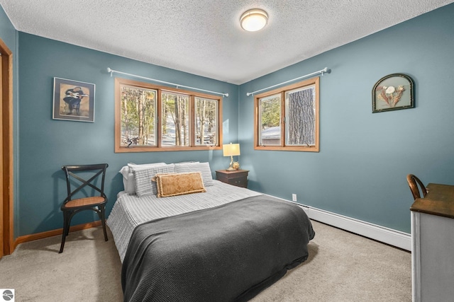 carpeted bedroom with a textured ceiling, baseboard heating, and baseboards