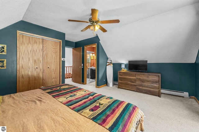 carpeted bedroom with baseboards, a baseboard radiator, vaulted ceiling, a textured ceiling, and a closet