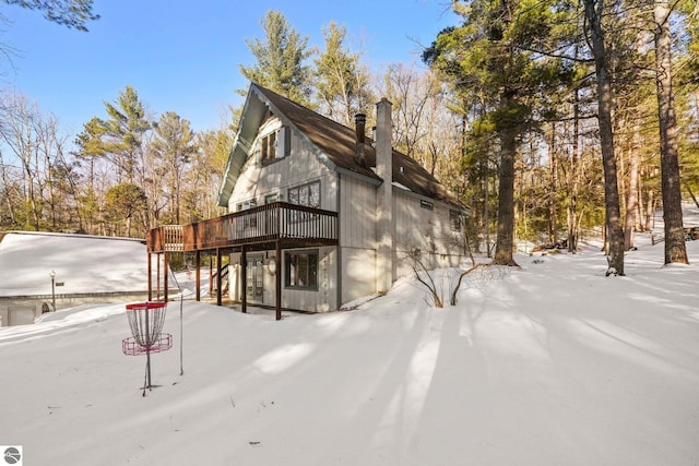 view of side of home with a chimney and a deck