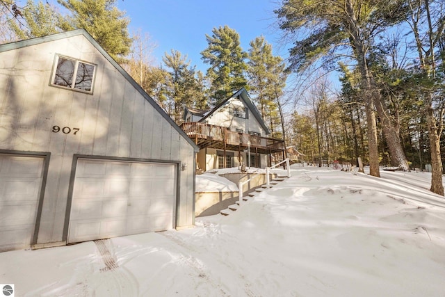 view of side of home with a deck, stairs, and a garage