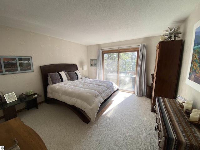 carpeted bedroom with access to exterior and a textured ceiling