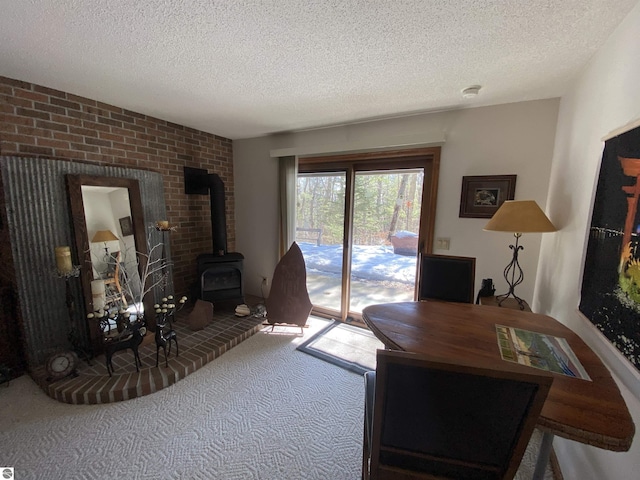 carpeted office with a textured ceiling and a wood stove