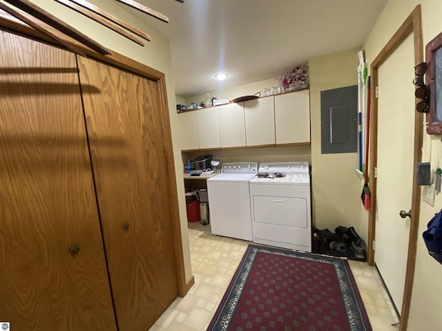 laundry room with cabinet space, electric panel, washing machine and clothes dryer, and light floors