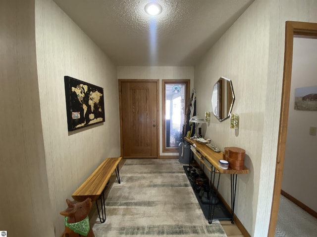 foyer with light colored carpet and a textured ceiling