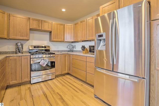 kitchen featuring light wood finished floors, recessed lighting, stainless steel appliances, and light stone countertops