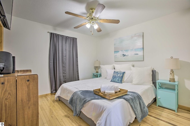 bedroom with light wood finished floors, ceiling fan, and baseboards