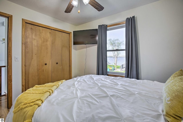 bedroom with ceiling fan, a closet, and wood finished floors