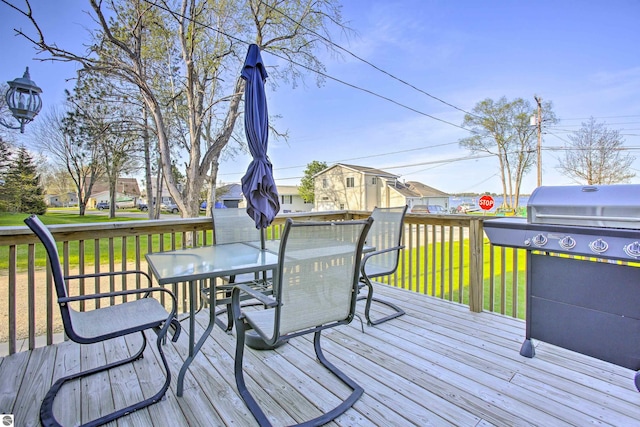 deck featuring a yard, a grill, and outdoor dining space