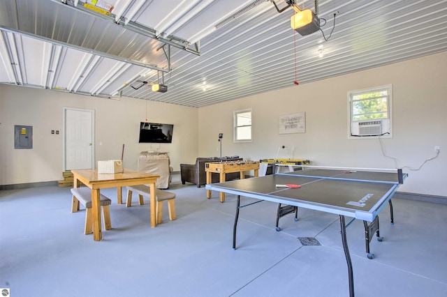 rec room featuring electric panel, a garage, and finished concrete floors