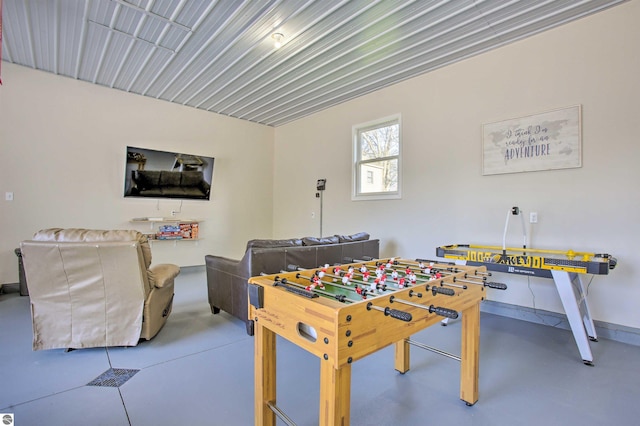 rec room featuring baseboards and finished concrete flooring