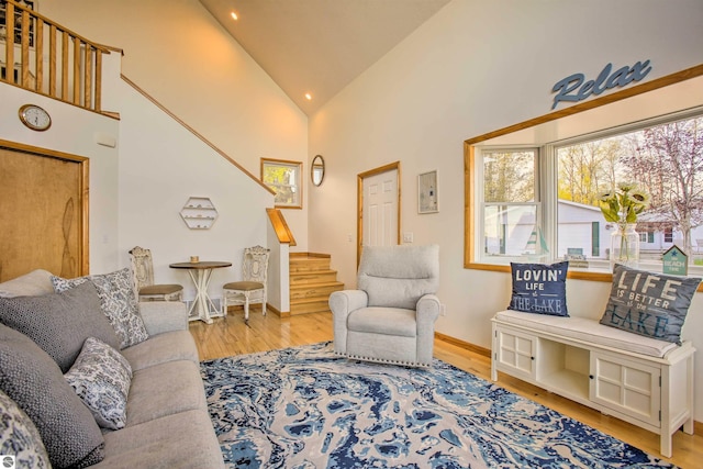 living room with stairway, baseboards, high vaulted ceiling, and wood finished floors