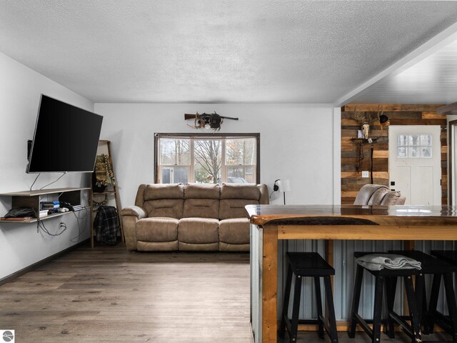 living area with a textured ceiling and wood finished floors