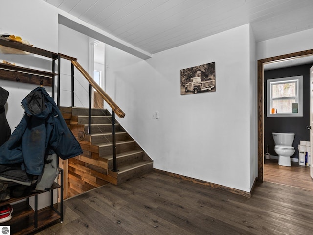 stairway with wooden ceiling, wood finished floors, and baseboards