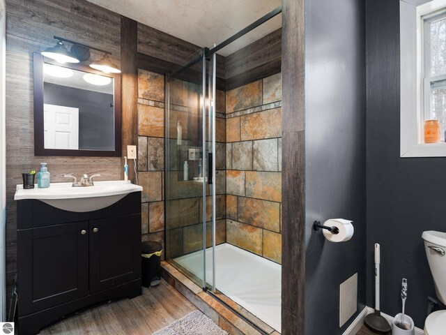 bathroom featuring a stall shower, vanity, toilet, and wood finished floors