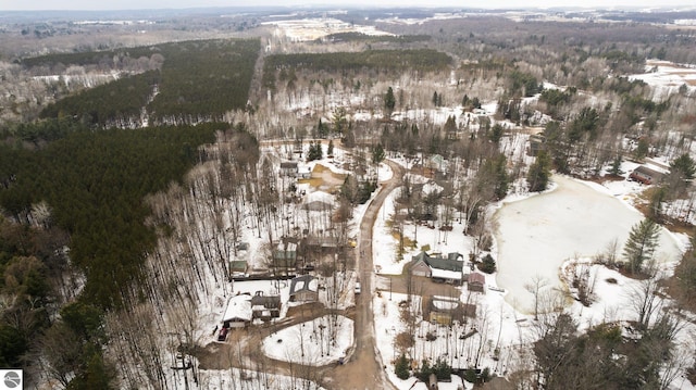 snowy aerial view featuring a forest view