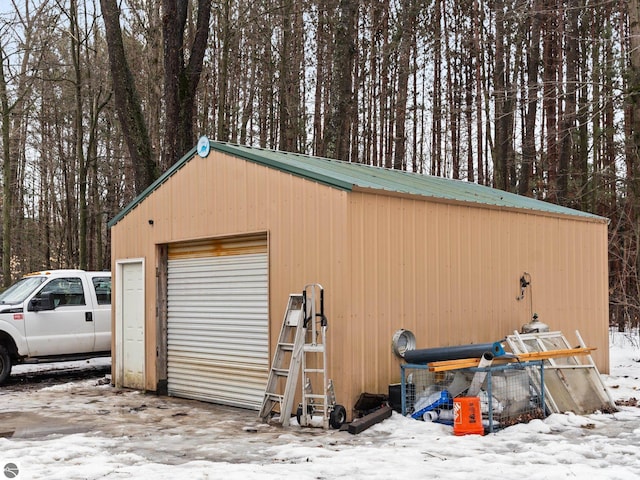 snow covered garage featuring a detached garage