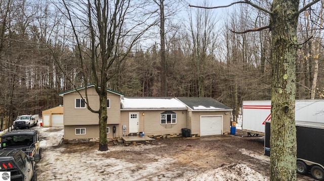 tri-level home featuring an outbuilding and dirt driveway