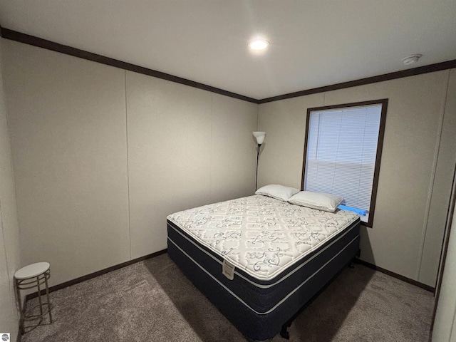 bedroom with crown molding, dark carpet, and baseboards