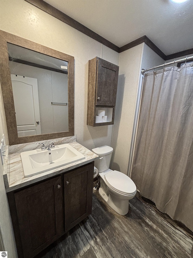 full bath featuring a shower with shower curtain, toilet, wood finished floors, a textured ceiling, and vanity