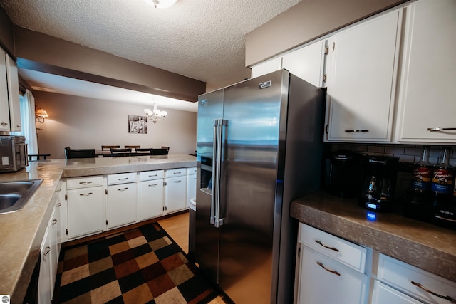 kitchen with a textured ceiling, dark floors, white cabinets, and high end fridge