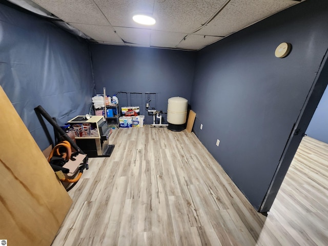 interior space with a paneled ceiling and wood finished floors