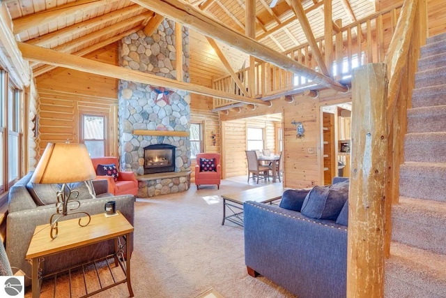 carpeted living area featuring a fireplace, wood ceiling, stairs, beamed ceiling, and rustic walls