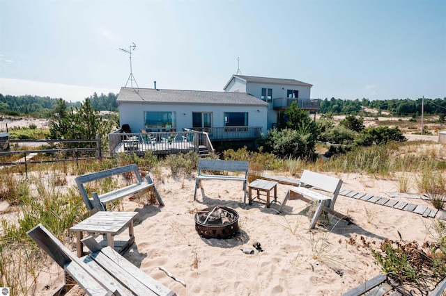 rear view of property featuring an outdoor fire pit and a deck