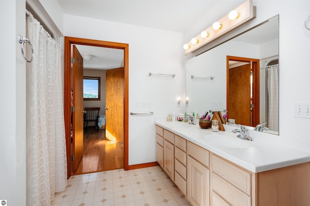 full bathroom with tile patterned floors, a sink, baseboards, and double vanity