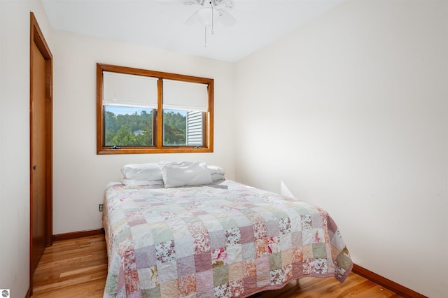 bedroom featuring light wood-style floors, baseboards, and a ceiling fan