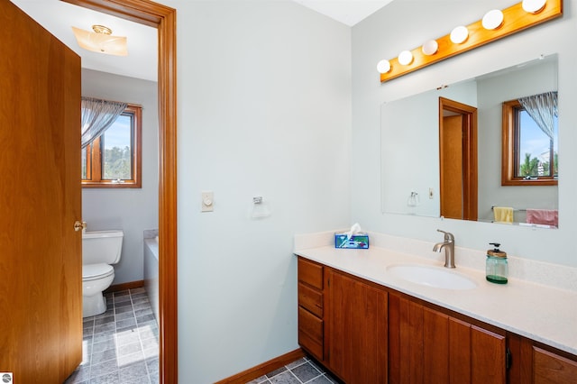 bathroom featuring toilet, tile patterned floors, baseboards, and vanity