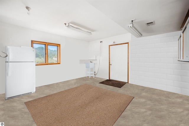 garage with freestanding refrigerator and visible vents