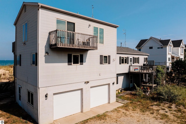 rear view of property featuring a garage and stucco siding