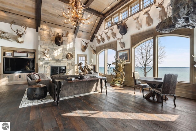 living area with beam ceiling, wood ceiling, a wealth of natural light, and wood-type flooring