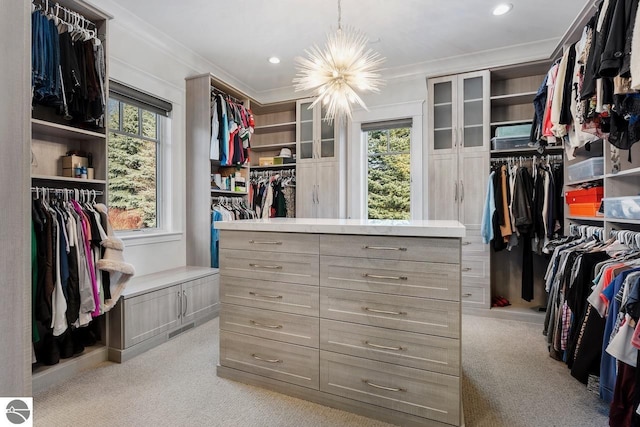 spacious closet featuring a notable chandelier and light colored carpet