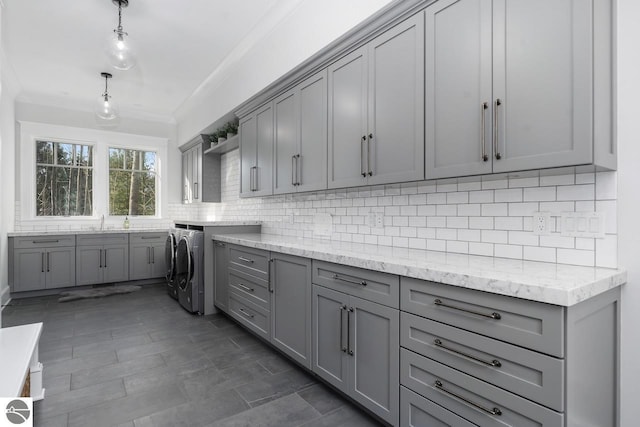 kitchen with decorative backsplash, washer / dryer, gray cabinetry, and crown molding