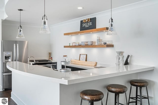 kitchen featuring appliances with stainless steel finishes, a peninsula, crown molding, and dark wood-type flooring