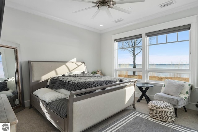 carpeted bedroom with visible vents, a water view, ceiling fan, and ornamental molding