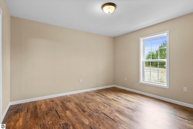 empty room with baseboards and wood finished floors