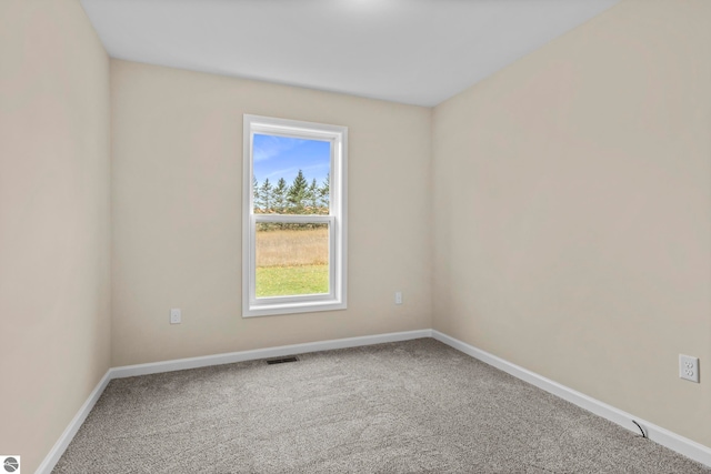 empty room with visible vents, carpet, and baseboards