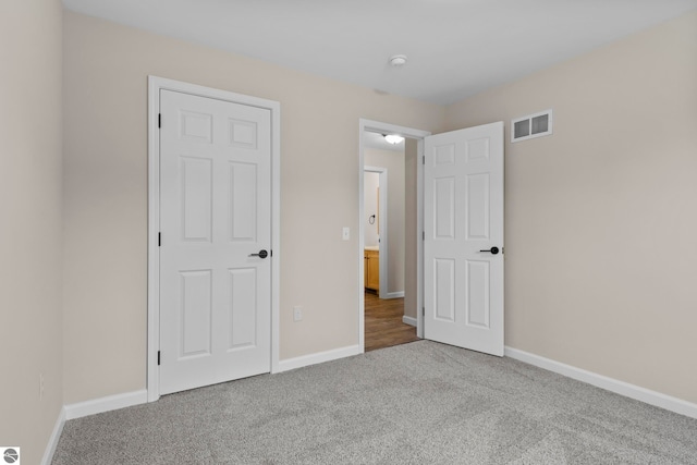 unfurnished bedroom with visible vents, baseboards, and carpet flooring