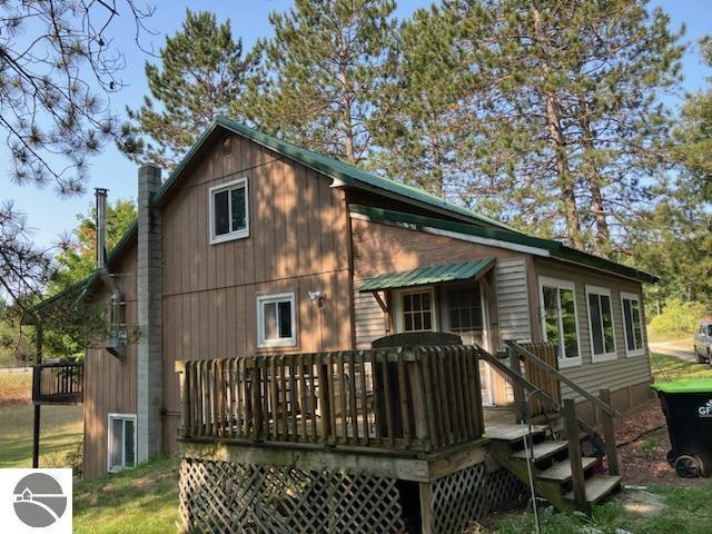 rear view of house with a chimney and a wooden deck